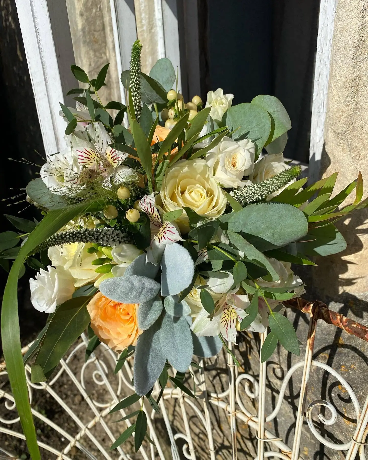 Cream and peach wedding bouquet with greenery