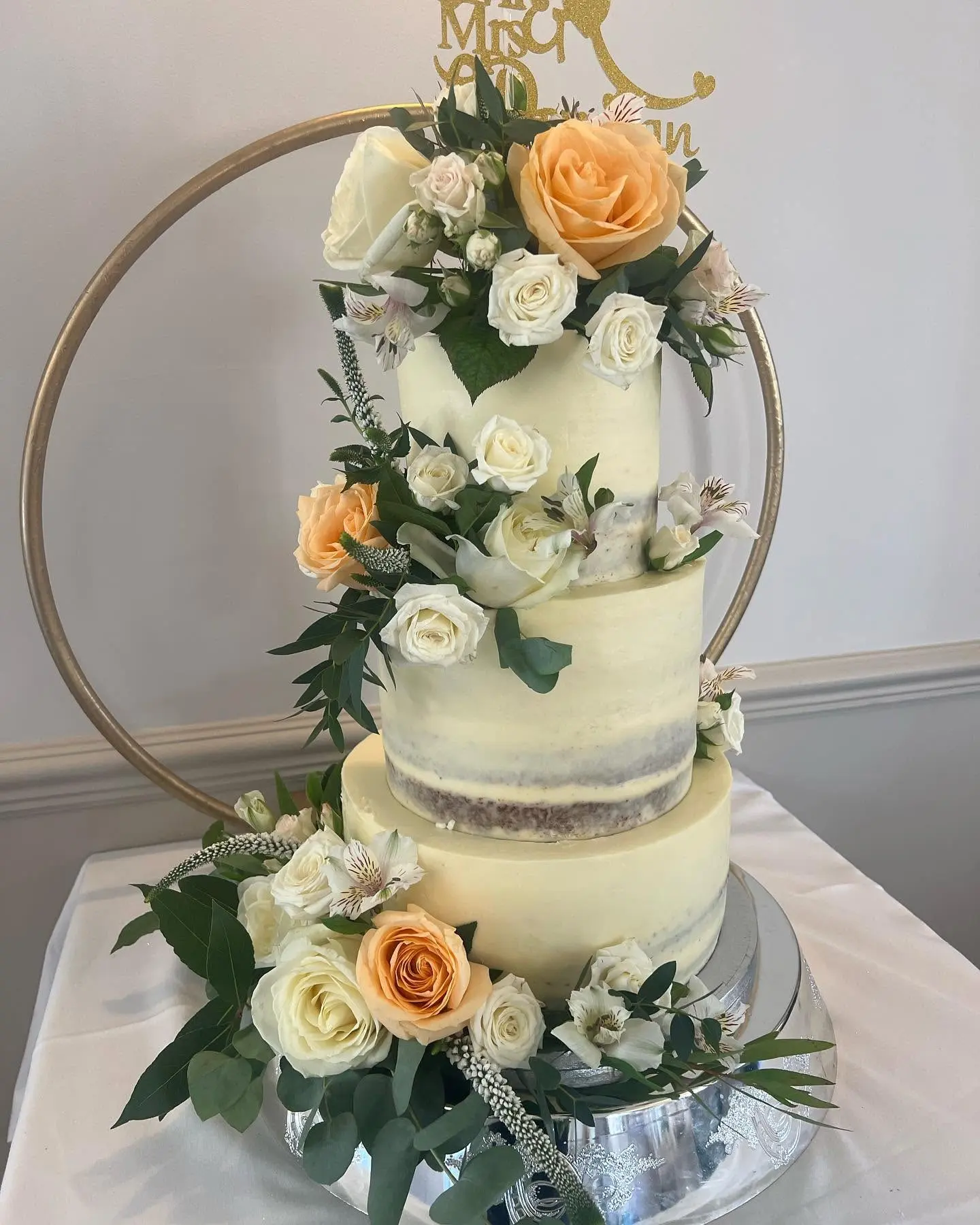 Wedding cake decorated with cream and peach flowers