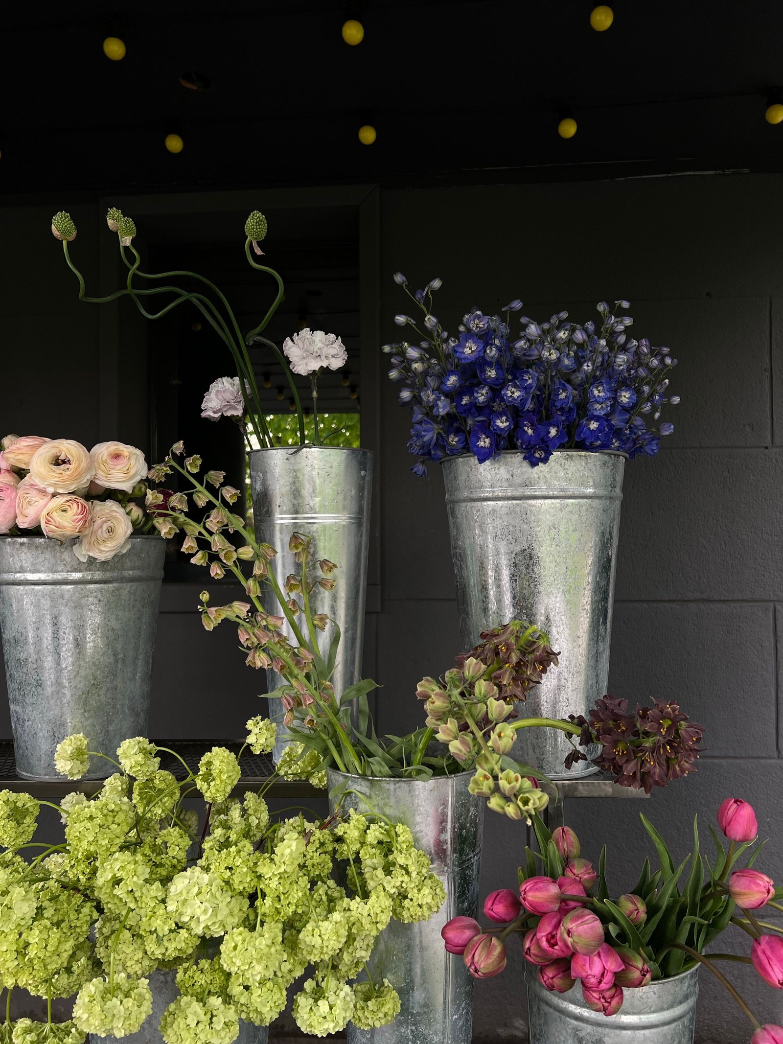 Fresh flowers arranged in metal buckets at a florist
